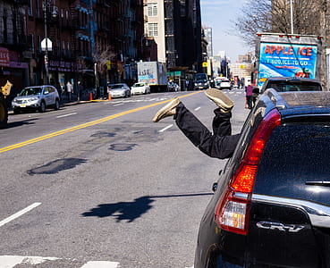 person's feet sticking out window of black Honda CR-V parked at roadside at daytime thumbnail