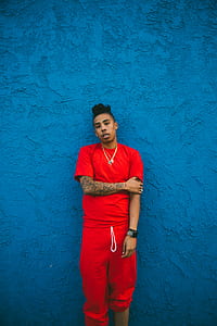 man in red t-shirt and red sweatpants standing beside wall thumbnail