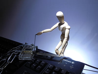 white robot toy beside black computer keyboard thumbnail