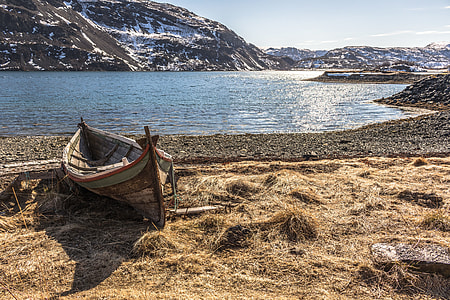 brown canoe on seashore during daytime thumbnail