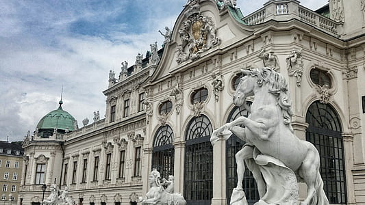 white concrete building near horse statue at daytime thumbnail