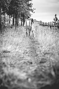 grayscale photo of man facing woman outdoor during daytime thumbnail