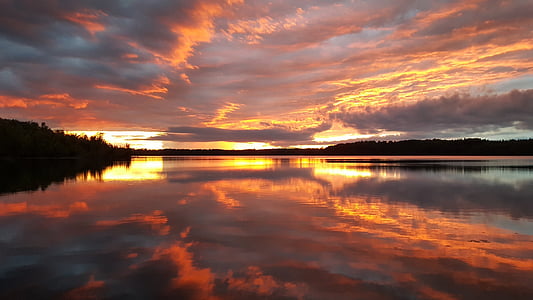 silhouette photography of land mas surrounding body of water thumbnail