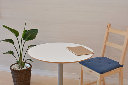 round brown wooden table beside plant thumbnail