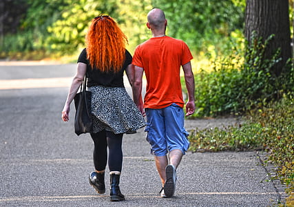 man and woman walking near trees and grasses thumbnail