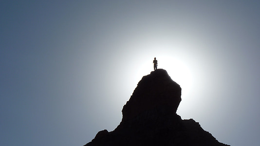 silhouette person standing on peak of mountain thumbnail