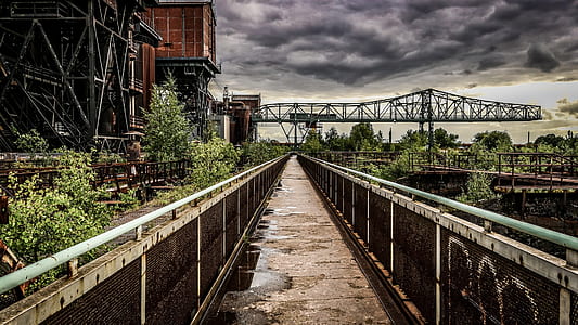 gray metal bridge under black clouds at daytime thumbnail