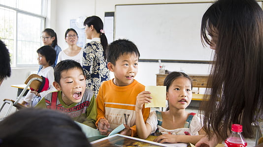 children looking at black-haired woman thumbnail