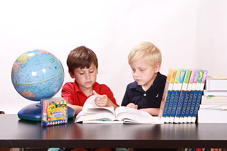 two boys sitting on chair reading book thumbnail