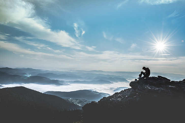 person sitting on cliff