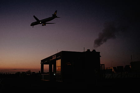 silhouette of flying airplane above store thumbnail