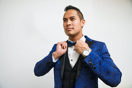 Man Adjusts Blue Tuxedo Bowtie Photo thumbnail