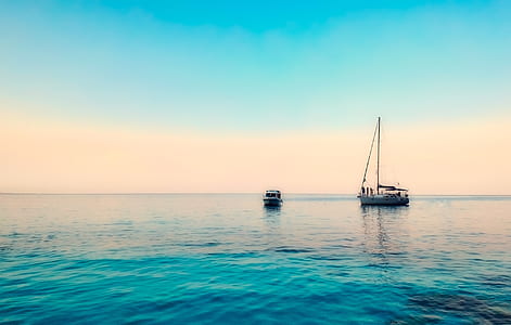 white sailing boat on green sea during daytime thumbnail