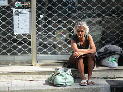 woman wearing gray scoop neck shirt seating near teal bag during day time thumbnail