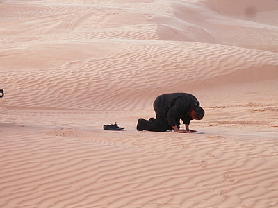 man kneeling down on desert thumbnail