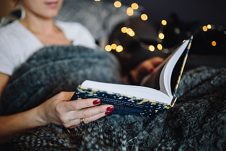 Young woman at home reading Hygge book and drinking thumbnail