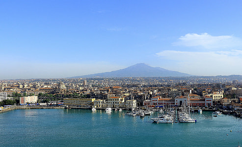 aerial photo of city beside body of water under clear blue sky during daytime thumbnail