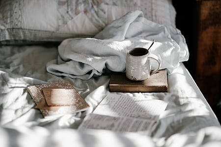 white mug on brown board beside white textile thumbnail