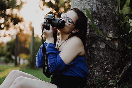 woman holding black DSLR camera thumbnail