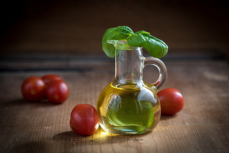 glass jug filled with oil with tomatoes on the table thumbnail