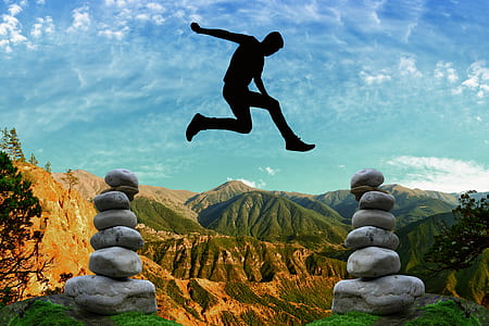 man jumps in between two cairns thumbnail