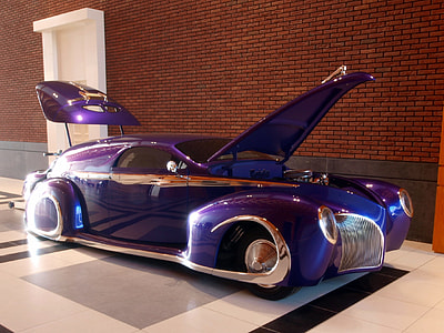 classic purple vehicle parked beside brown wall thumbnail