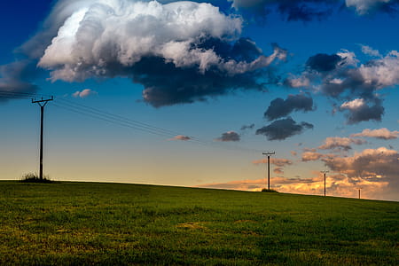 Amazing meadow with epic blue sky with big clouds at early evening thumbnail
