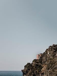 house on top of high ground near body of water thumbnail