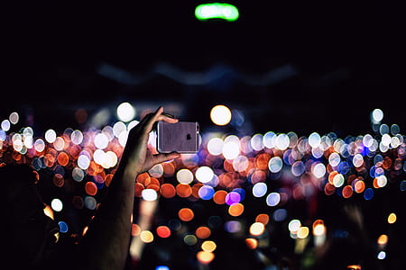 person holding iPhone bokeh lights thumbnail