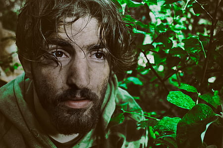 man in green hoodie near green leaf plants thumbnail