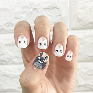 Person's Left Hand Showing White Nail Polish thumbnail