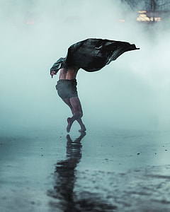 person in grey shorts with black leather jacket running on street with fogs thumbnail