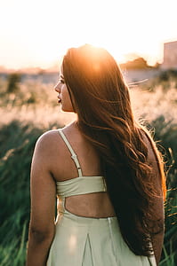 selective focus photography of woman standing on grass field thumbnail