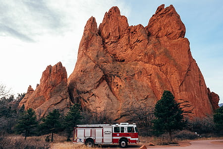 firetruck parked against brown rock hill thumbnail