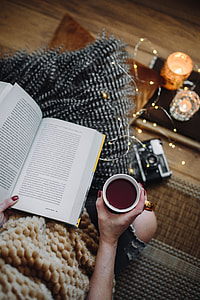 Woman drinking tea and reading book thumbnail