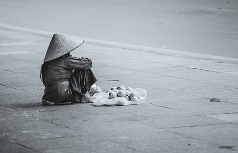 grayscale photo of a person sitting on gray road thumbnail