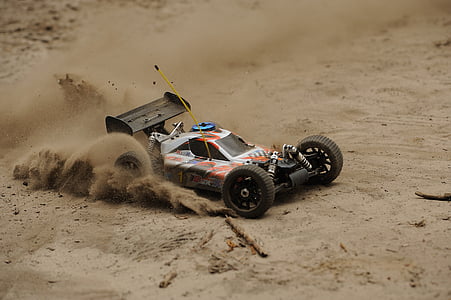 white and orange RC sand buggy toy car drifting on sand thumbnail
