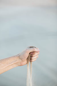person holding sand in hand thumbnail
