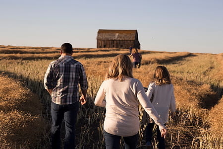 two women and one man on field during daytime thumbnail