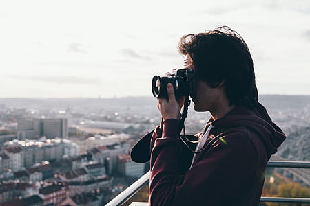 Man in Maroon Jacket Using Camera thumbnail