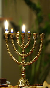 gold-colored hanuka candle with four lighted candle thumbnail