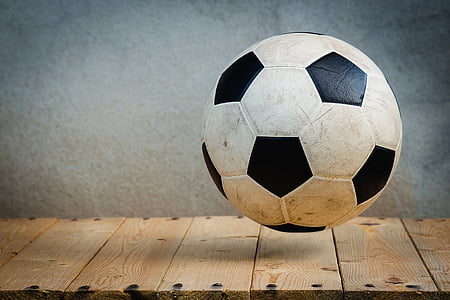 white soccer ball over the brown wooden panel thumbnail