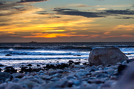 photo of seashore near sea during golden hour thumbnail