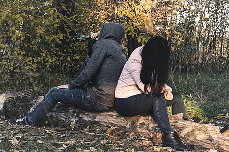 two people sitting on tree log thumbnail