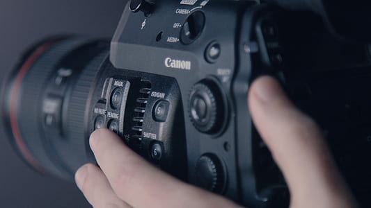 person holding black Canon DSLR camera thumbnail
