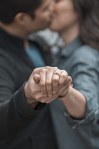 man and woman kissing while holding hands thumbnail
