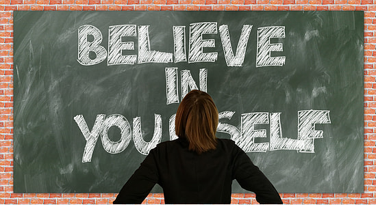 person in black long-sleeved top facing blackboard with believe in yourself text thumbnail