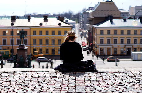 blonde hair woman in black sweater sitting on bricked floor during daytime thumbnail