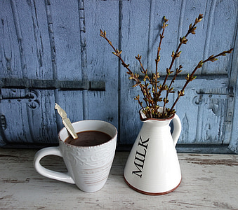 white ceramic mug beside vase thumbnail