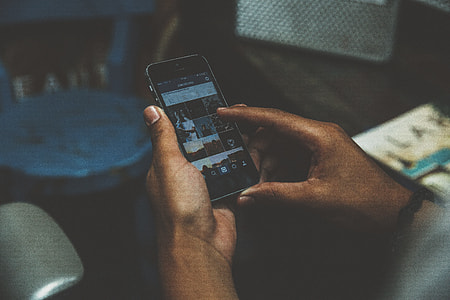 person holding smartphone displaying Instagram application thumbnail